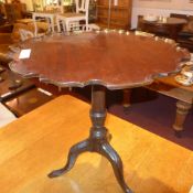 A Georgian mahogany pie crust occasional table raised on turned column and tri form supports (A/F)