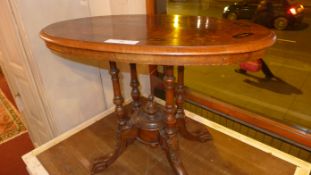 A Victorian inlaid walnut oval occasional table raised on four turned columns and quadruped