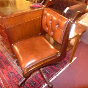 A mahogany swivel office chair with tan leather button back and leather seat with studded detail