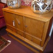 A Heals 1920`s honey oak sideboard fitted arrangement of four drawers and pair of cupboard doors