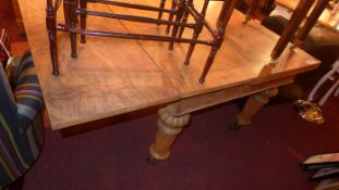 A C19th Pollard oak draw leaf dining table raised on heavy supports and castors