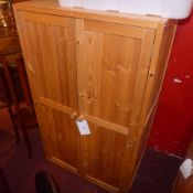 A contemporary pine side cabinet with pair of panel doors enclosing shelves