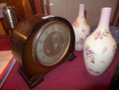 A 1950s oak cased mantel clock with circular steel dial and a pair of vases decorated with flowers
