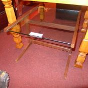 A Danish style low table the square glass top raised on teak supports