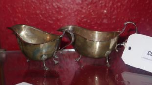 A pair of hallmarked silver sauce boats raised on pad feet