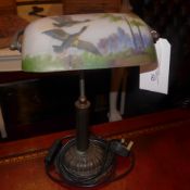 A desk lamp, the frosted glass shade with hand printed scene of flying ducks.