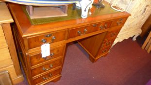 A yew wood pedestal desk the tooled leather top above arrangement of drawers