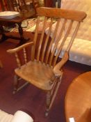 A C19th stick back rocking chair with solid seat raised on turned supports