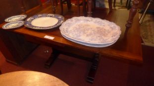 An oak draw leaf dining table raised on heavy turned supports