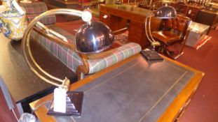A pair of Art Deco style desk lamps with overhanging shades on adjustable supports