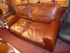 A contemporary designer three seater sofa upholstered in brown leather