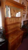 An old pine dresser the open shelf upstand above two drawers and pair of panelled doors on bracket