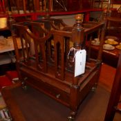 A mahogany Canterbury of three divisions terminating on turned supports and fitted single drawers