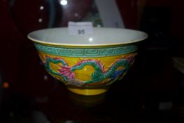 A Chinese bowl with brightly coloured glaze and dragons in relief