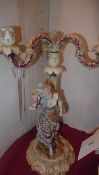 A pair of C19th Continental porcelain  candelabra in the form of lady and gent heightened in gilt (