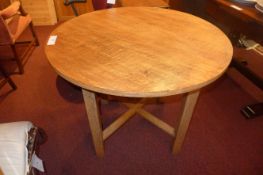 A Heals oak kitchen table the circular top raised on stretchered supports