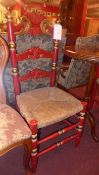 A pair of country ladder back chairs painted red and parcel gilt with carved backs rush seats and