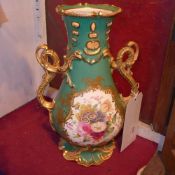 A pair of Continental twin handled vases with flowers and heightened in gilt