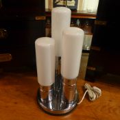 A vintage chrome lamp with three opaque shades