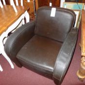 A dark brown castle Gibson retailed leather armchair raised on cylindrical feet
