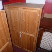 A contemporary pine side cabinet with pair of panel doors enclosing shelves