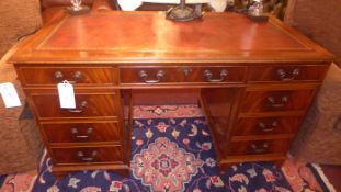 A mahogany pedestal desk the leather top above arrangement of drawers with brass handles