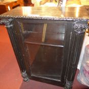 A C19th ebonised pier cabinet the single glazed panel door flanked by Corinthium style columns
