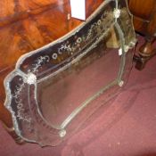 An early C20th Venetian looking glass the shaped plate within bevelled edge frame with etched flower