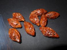 A set of nine C19th Chinese carved and pierced nut beads