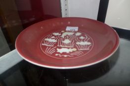 A Chinese shallow dish glazed red and white with fish and water plant detail