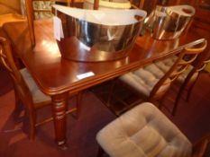 A Victorian style mahogany extending dining table with one extra leaf and raised on reeded