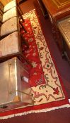 A handmade Persian rug with a red field surrounded by a frieze border 267 cm x 154 cm