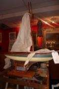 A handmade wooden pond yaught with original sails and a stand (A/F)