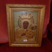 An Eastern European Icon with Madonna and child in relief glazed and framed in giltwood frame