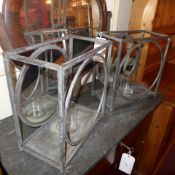 A pair of wrought metal garden candle holders with circular mirrored backs