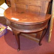 An C18th demi lune mahogany tea table raised on cabriole and pad foot supports