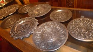 A collection of eight continental white metal chargers and dishes