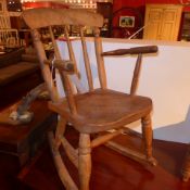 An elm childs rocking chair with spindle stick back above solid seat