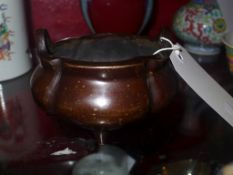 A Chinese bronze twin handled bowl raised on three feet