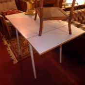 A retro formica topped twin flap kitchen table raised on metal supports