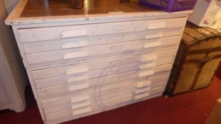 A painted distressed finish oak plan chest fitted nine drawers on plinth base
