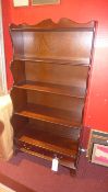 A mahogany waterfall style open bookcase fitted with two base drawers
