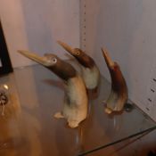 A set of three carved horn figurines of penguins