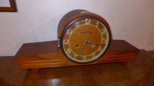 A Continental Art Deco walnut mantel clock with circular dial and inlaid detail