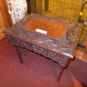 A Chinese hardwood occasional table with profuseley carved detail and dragons in relief