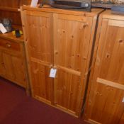 A contemporary pine side cabinet with pair of panel doors enclosing shelves