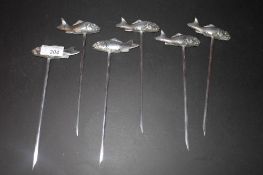 A set of six white metal fish skewers with fish handles