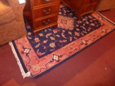 A handmade Persian rug with a central medallion on a midnight blue field surrounded by a frieze