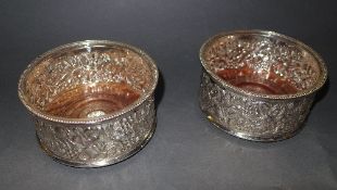A pair of silver plated wine coasters wi