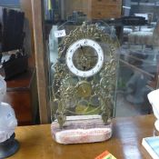 A large brass skeleton clock on blue Joh